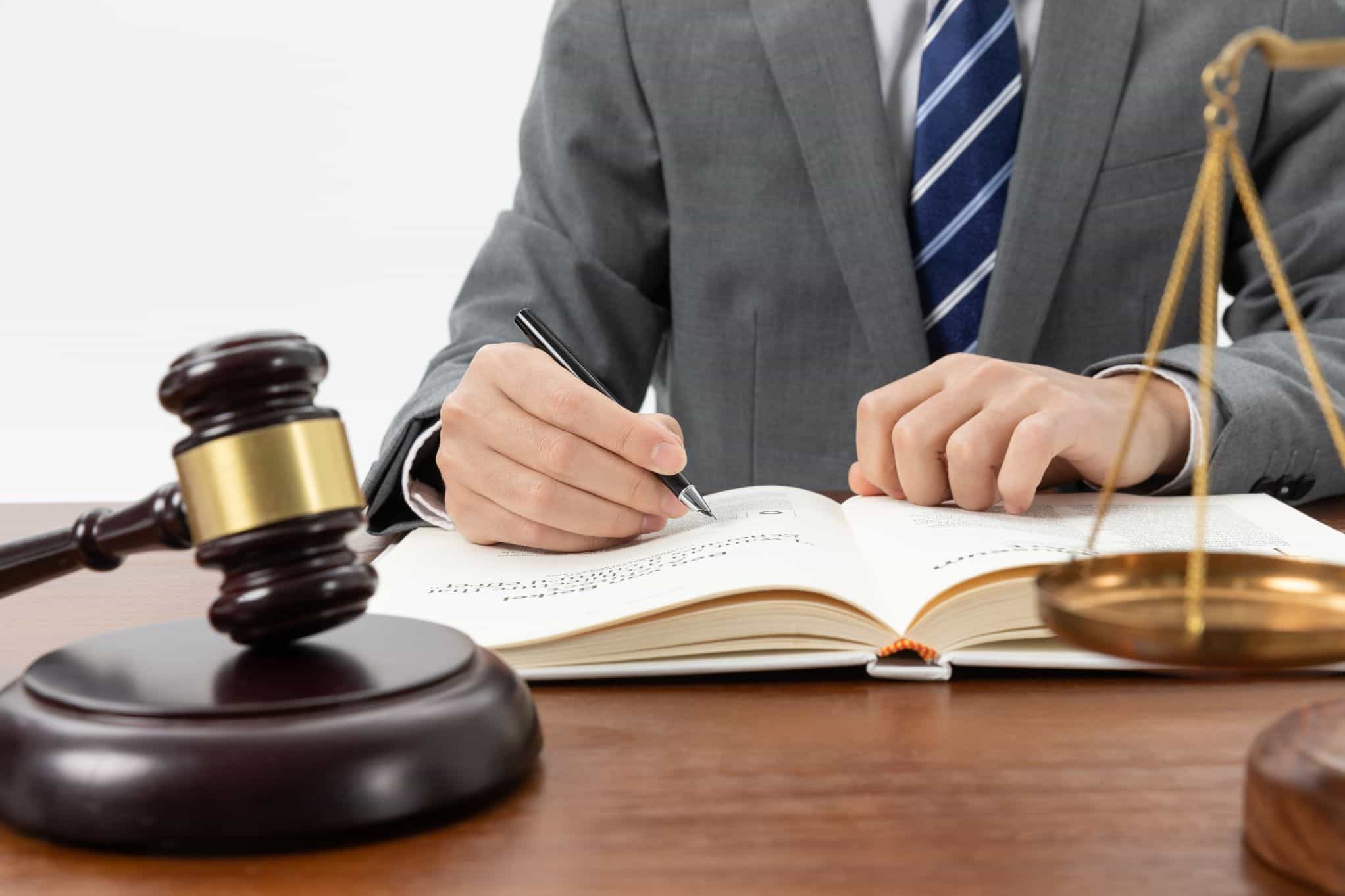 closeup-shot-person-writing-book-with-gavel-table-1